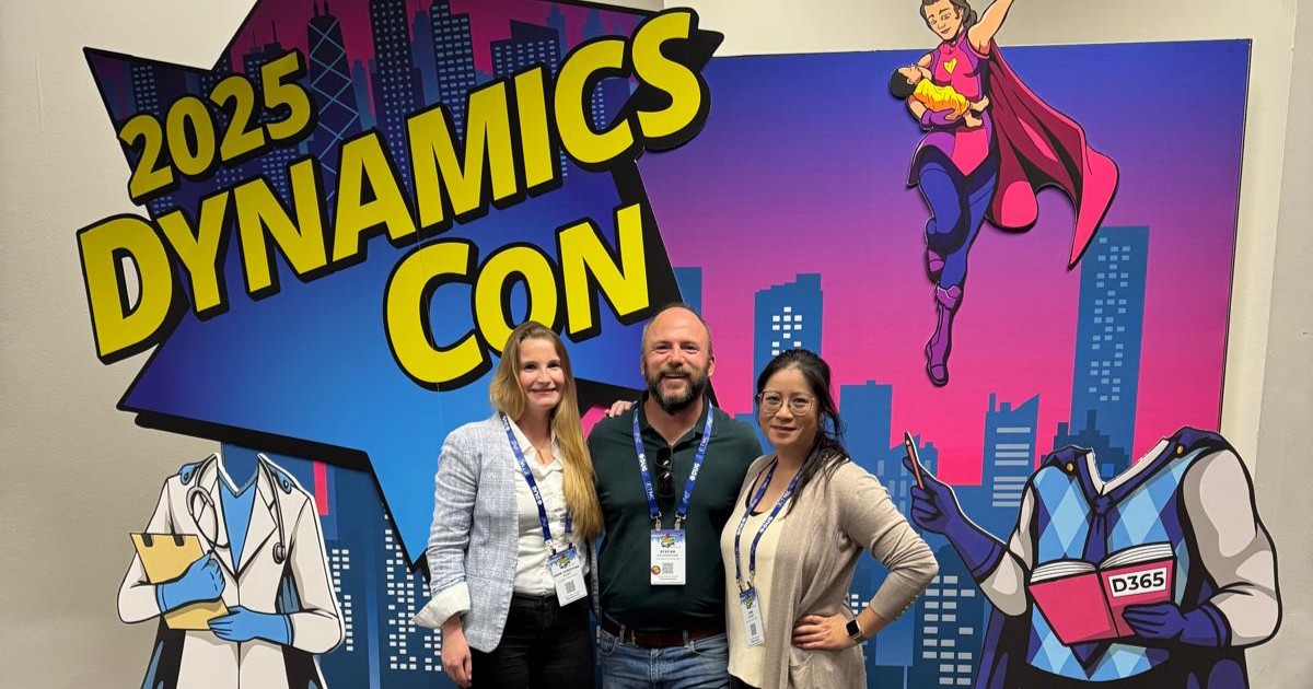 Christina Korff, Stefan Falkenhagen und Linh Schmidt stehen vor einem Banner der DynamicsCon 2025 und blicken in die Kamera